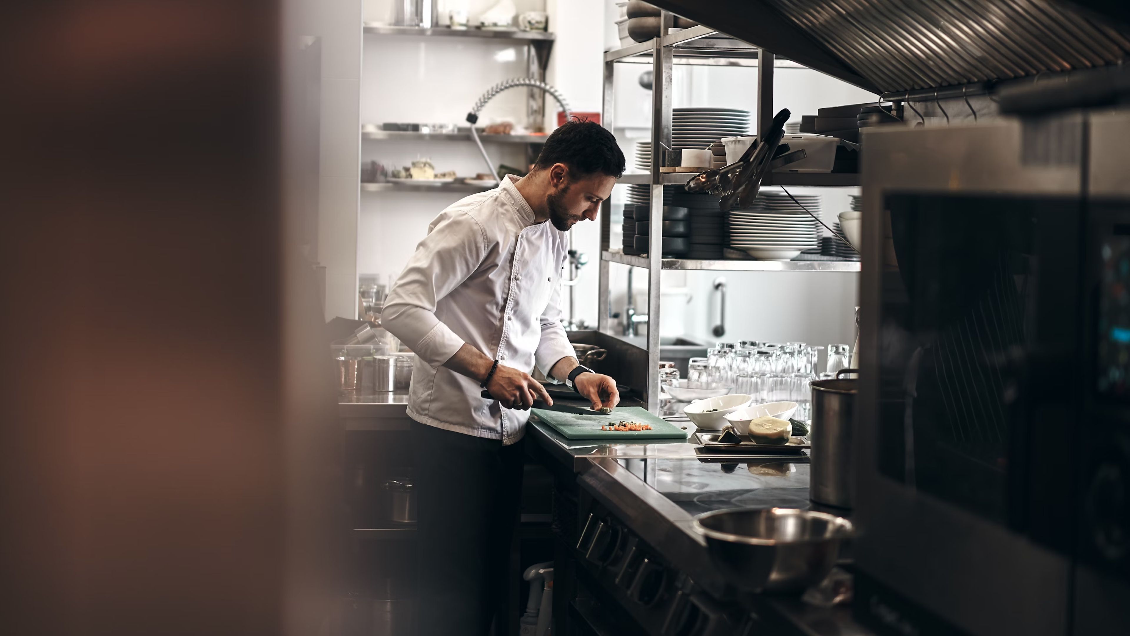 Four chefs making a delicious dish in a kitchen together.