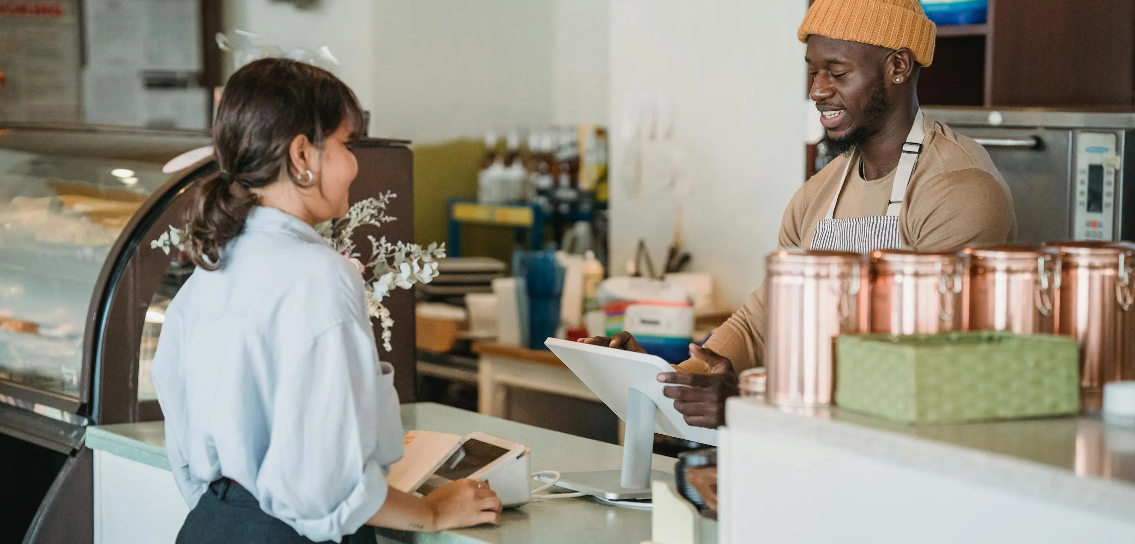 A customer checking out at a cafe counter