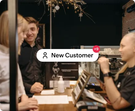 A group of people working at a table with the text "New Customer" highlighted in the center.